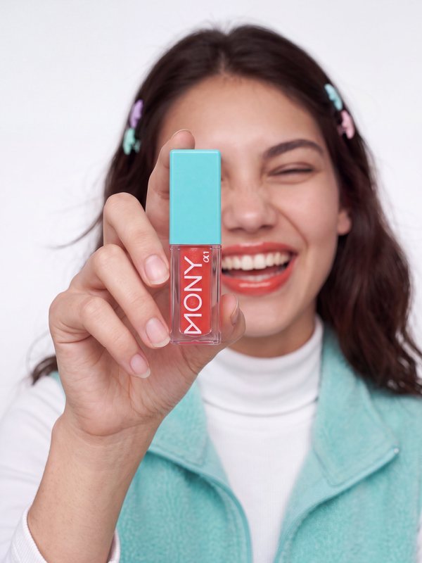 Beauty category: smiling model holding up a lip gloss