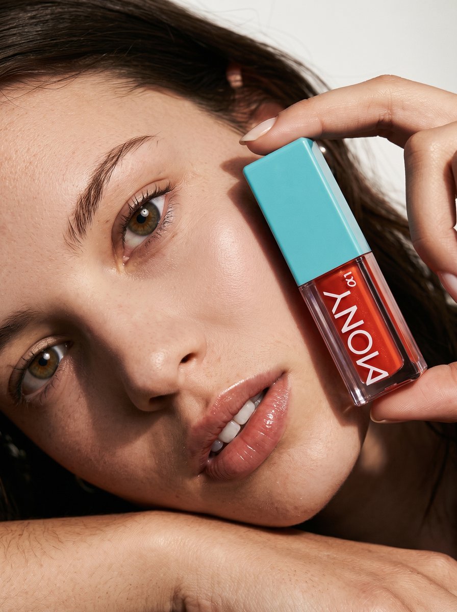Lifestyle brand Instagram ad creative: model holding a MONY lip gloss next to her face